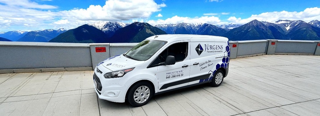 Weißer Ford Transit mit blauer Fahrzeugbeschriftung von Jürgens Fliesen & Innenausbau – erstellt von Folien Fischer Hamburg Bergedorf