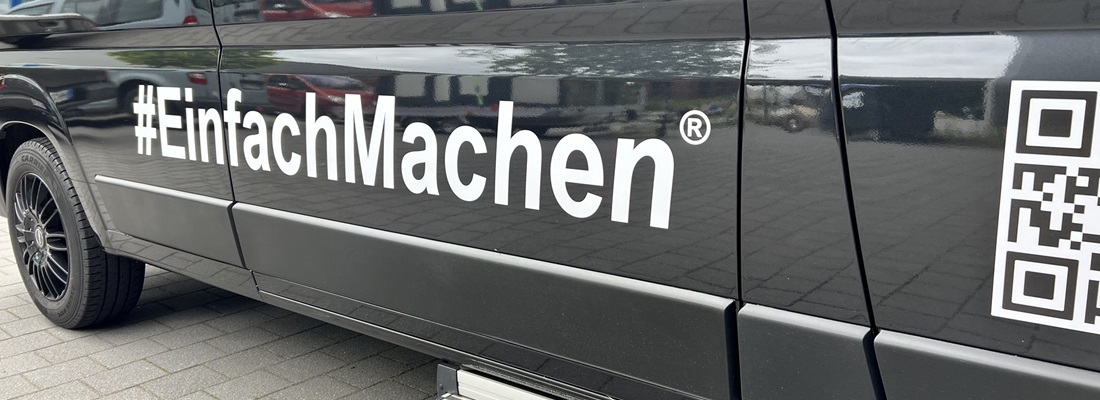 Schwarzer Transporter mit weißer Folienbeschriftung #EinfachMachen und QR-Code – Folien Fischer Hamburg